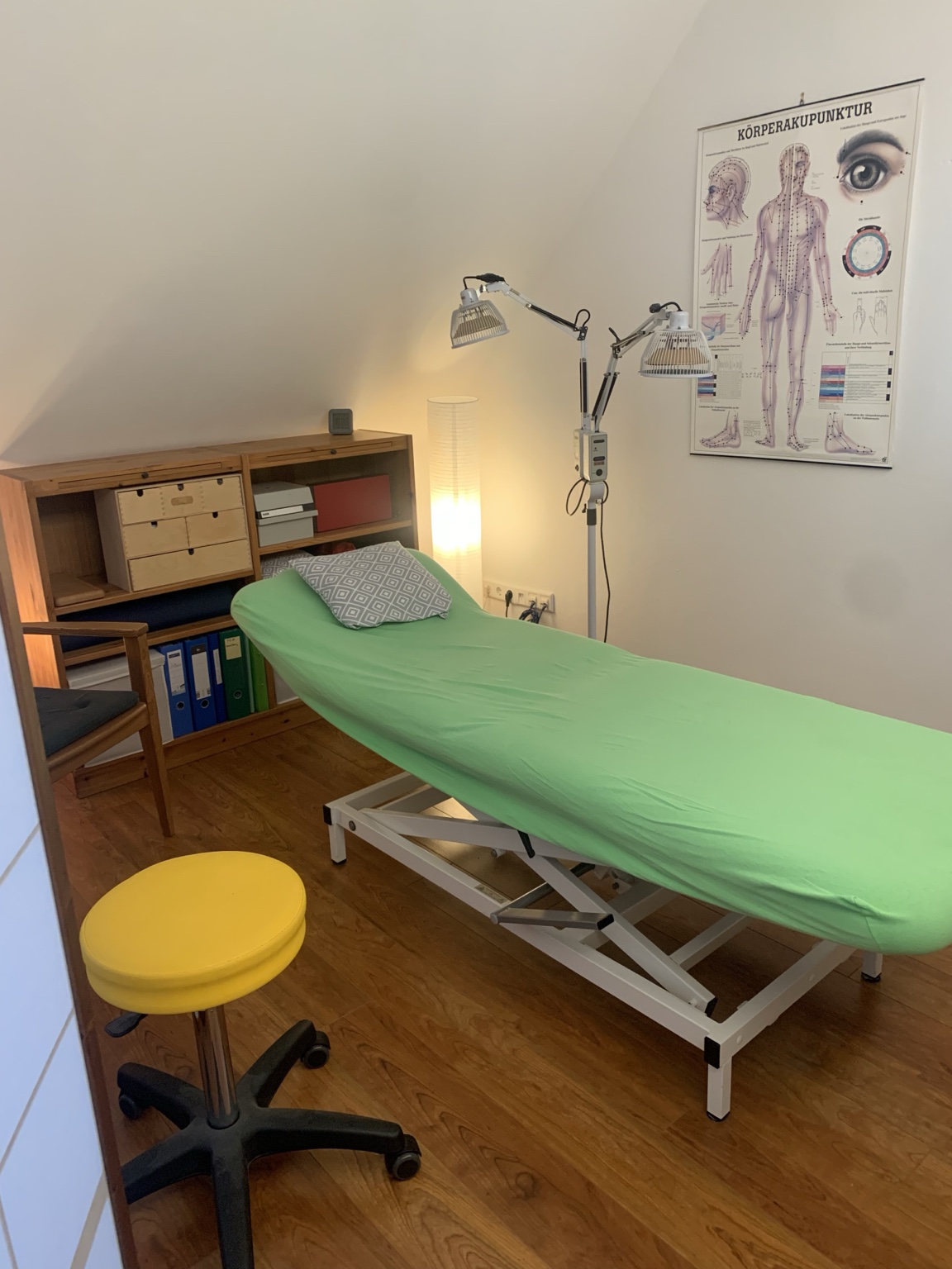 Behandlungsraum mit Behandlungsliege und Wärmelampen